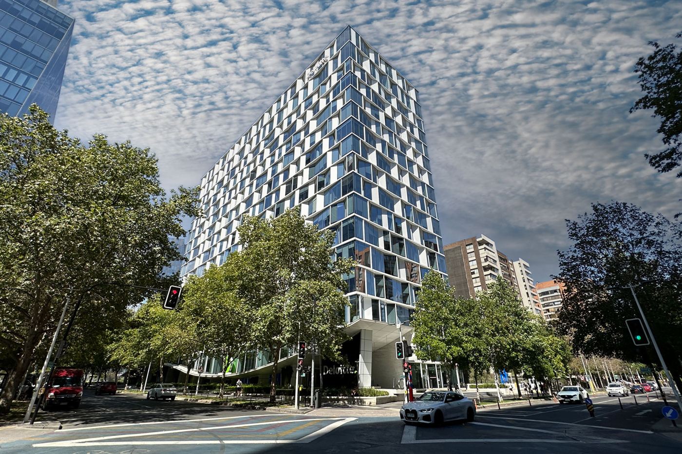 Torre del Edificio Rosario Norte desde la calle, entre árboles